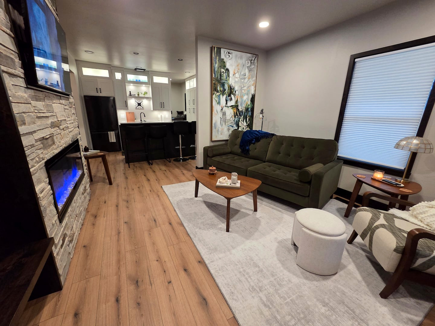 Front living room with fireplace, green sofa and big windows